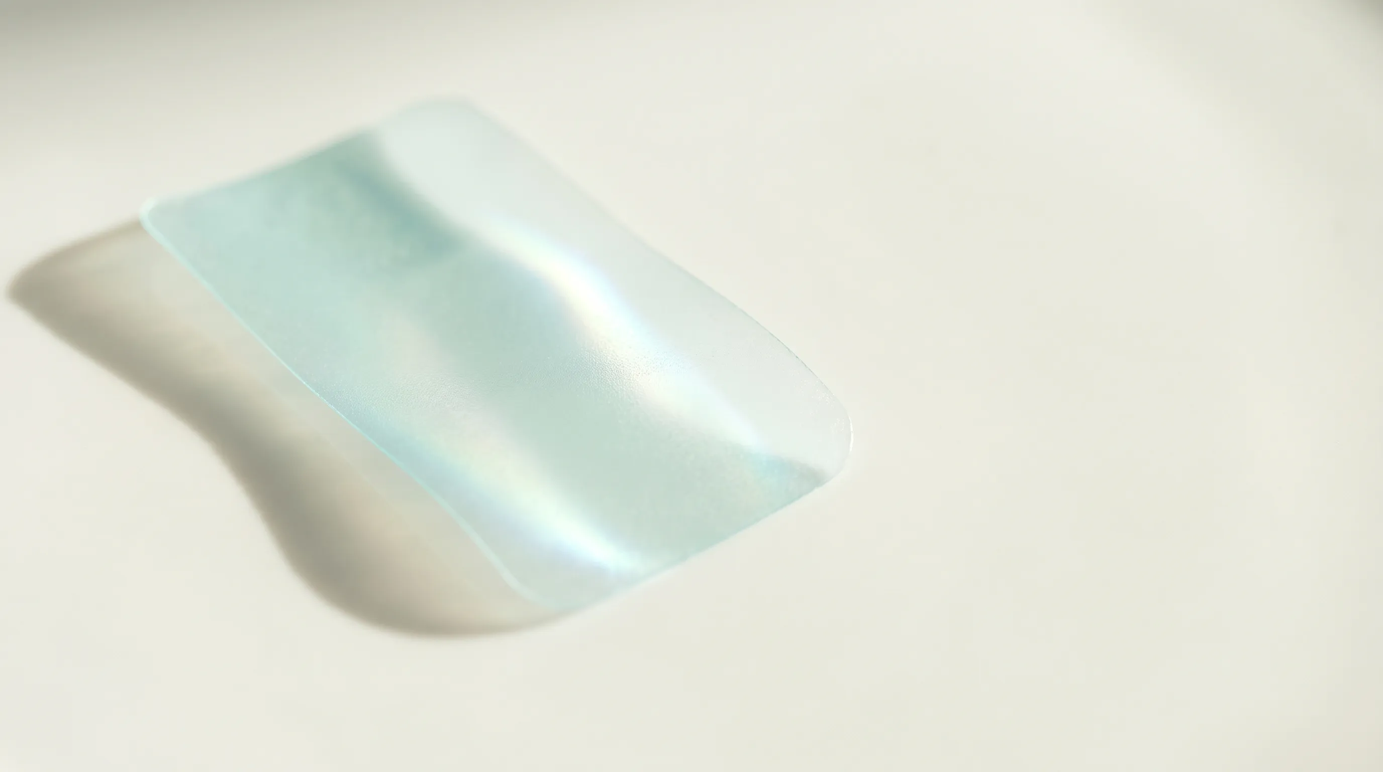 Macro photograph of a translucent pale aqua oral strip on a porcelain surface